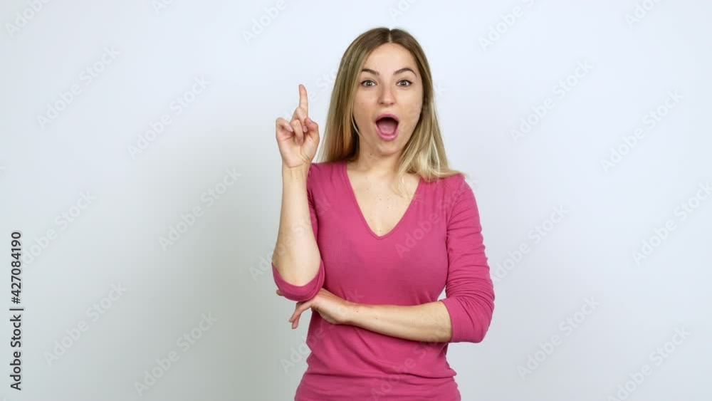 Young woman standing and thinking an idea pointing the finger up over isolated background