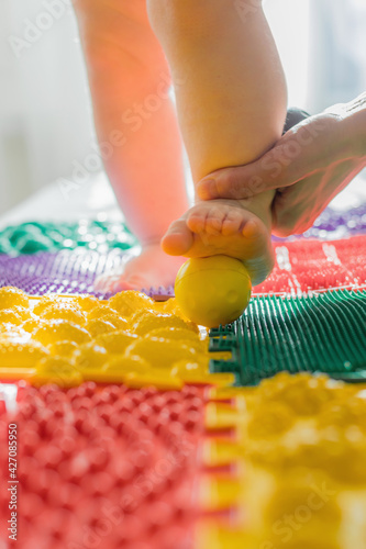 Mom gives the baby a foot massage with massage balls.
