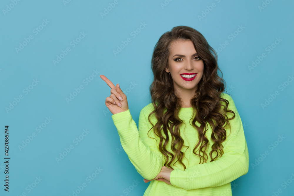 Fototapeta premium Young Smiling Woman Is Pointing Up