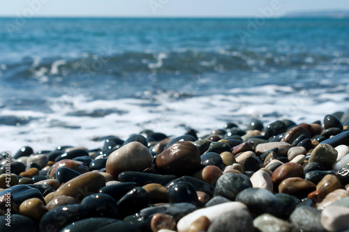 Wet stones and wave on sea beach