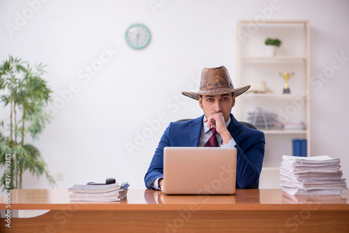 Young cowboy businessman working at workplace