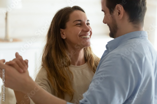 Bilde på lerret Happy millennial multiethnic man and woman dance waltz together at home, show love and affection in relationship