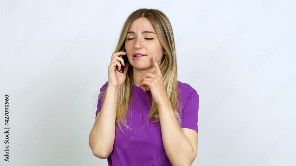Young woman talking on mobile phone having doubts and questioning an idea over isolated background Young woman talking on mobile phone having doubts and questioning an idea over isolated background