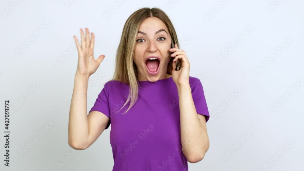 Young woman talking on mobile phone with surprise and shocked facial expression over isolated background Young woman talking on mobile phone with surprise and shocked facial expression over isolated background