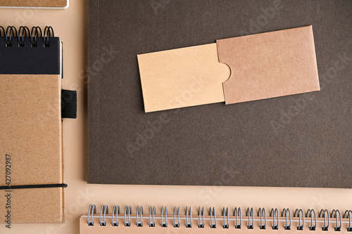 branding mockup with many craft paper and different subjects. Badge with place for text. Office desk with a paper notepad and a box of pencils. Contemporary workspace for men, minimalist style. Mockup photo