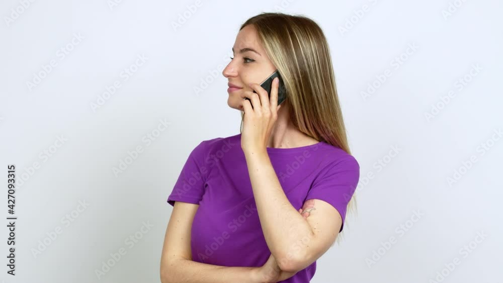 Young woman talking on mobile phone looking side over isolated background Young woman talking on mobile phone looking side over isolated background