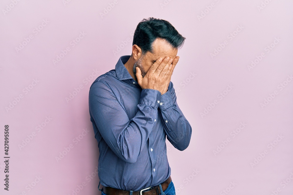 Middle age man with beard and grey hair wearing business clothes with sad expression covering face with hands while crying. depression concept. Middle age man with beard and grey hair wearing business clothes with sad expression covering face with hands while crying. depression concept.