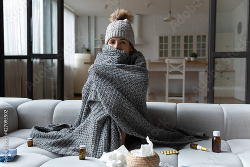 Fototapeta Sick latin female feel bad ill has health problems in cold freezing flat with broken central heating