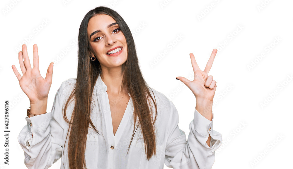 Young beautiful woman wearing casual white shirt showing and pointing up with fingers number eight while smiling confident and happy. Young beautiful woman wearing casual white shirt showing and pointing up with fingers number eight while smiling confident and happy.