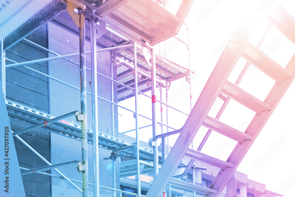 Fototapeta premium construction metal scaffolding, construction site for construction and renovation of buildings, bright pink solar lighting, civil engineering concept