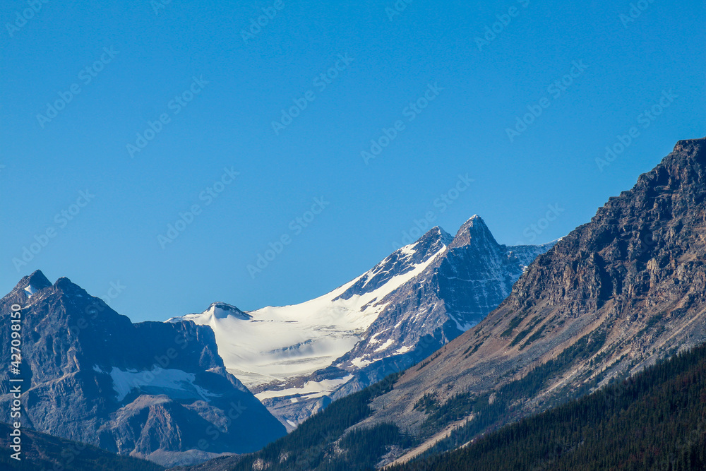 Snow capped mountains on sunny day with blue skies
