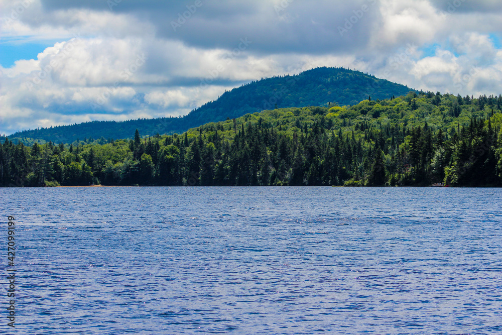 Lush green mountains with lake in forefront Lush green mountains with lake in forefront