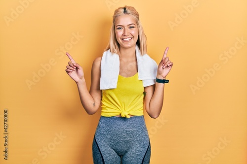 Beautiful blonde sports woman wearing workout outfit smiling confident pointing with fingers to different directions. copy space for advertisement