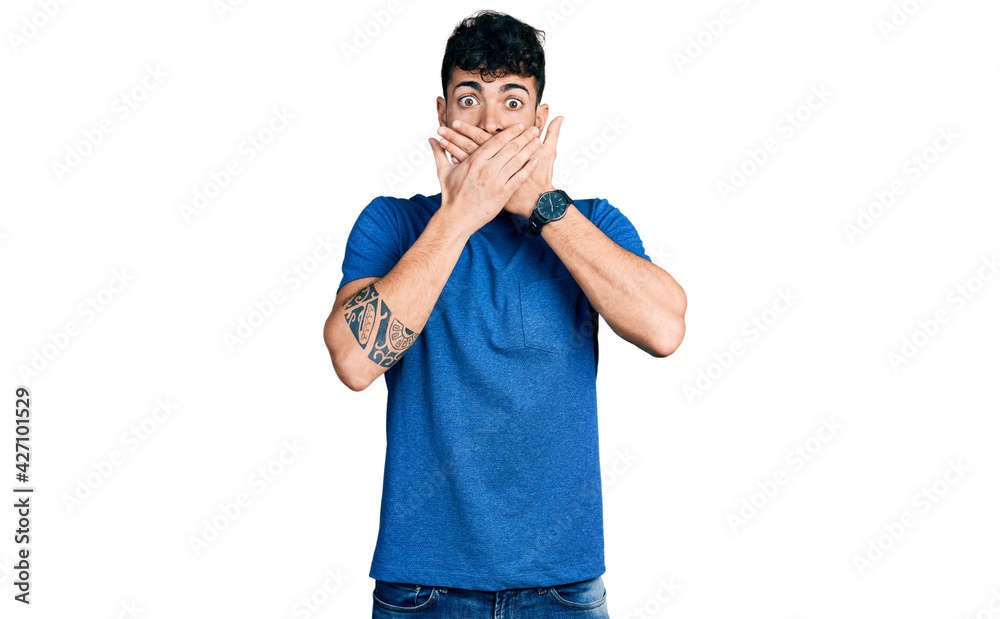 Fototapeta premium Young hispanic man wearing casual t shirt shocked covering mouth with hands for mistake. secret concept.