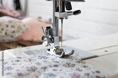 Sewing machine operation from different angles and sewing a flowered fabric. Selective Focus Machine part.