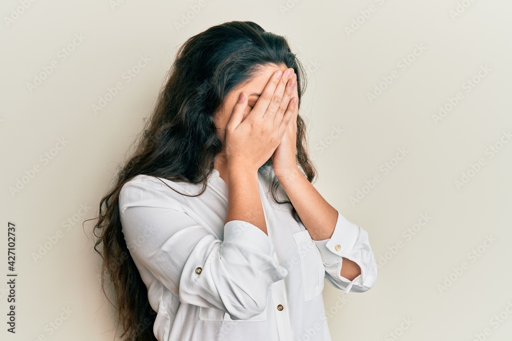 Beautiful middle eastern woman wearing casual clothes with sad expression covering face with hands while crying. depression concept. Beautiful middle eastern woman wearing casual clothes with sad expression covering face with hands while crying. depression concept.