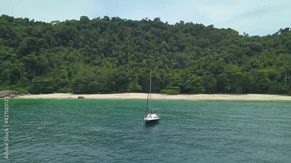 Aerial and slow motion view of a sailboat on a paradisiacal beach in the bay of Angra dos Reis, Rio de Janeiro, Brazil Aerial and slow motion view of a sailboat on a paradisiacal beach in the bay of Angra dos Reis, Rio de Janeiro, Brazil