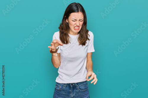 Young beautiful woman wearing casual white t shirt disgusted expression, displeased and fearful doing disgust face because aversion reaction.