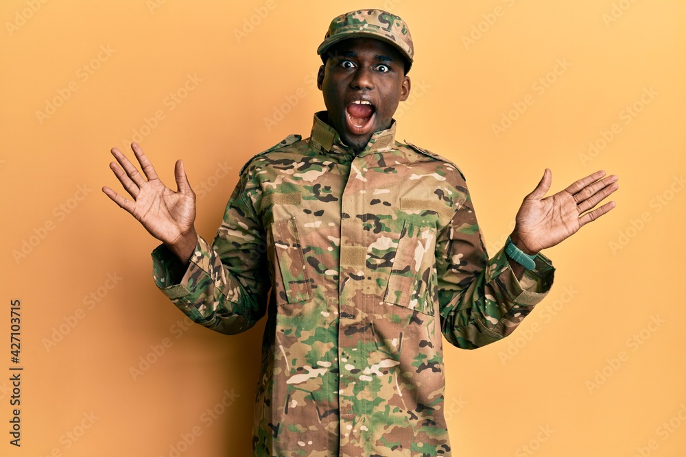 Young african american man wearing army uniform celebrating crazy and amazed for success with arms raised and open eyes screaming excited. winner concept Young african american man wearing army uniform celebrating crazy and amazed for success with arms raised and open eyes screaming excited. winner concept