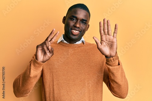 Young african american man wearing casual clothes showing and pointing up with fingers number seven while smiling confident and happy.