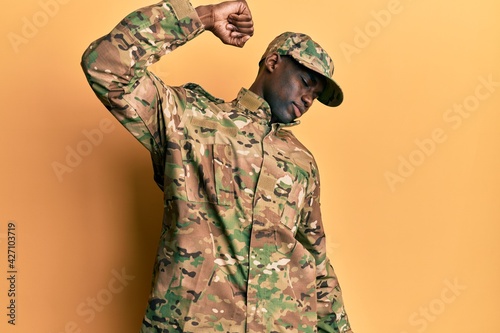 Young african american man wearing army uniform stretching back, tired and relaxed, sleepy and yawning for early morning