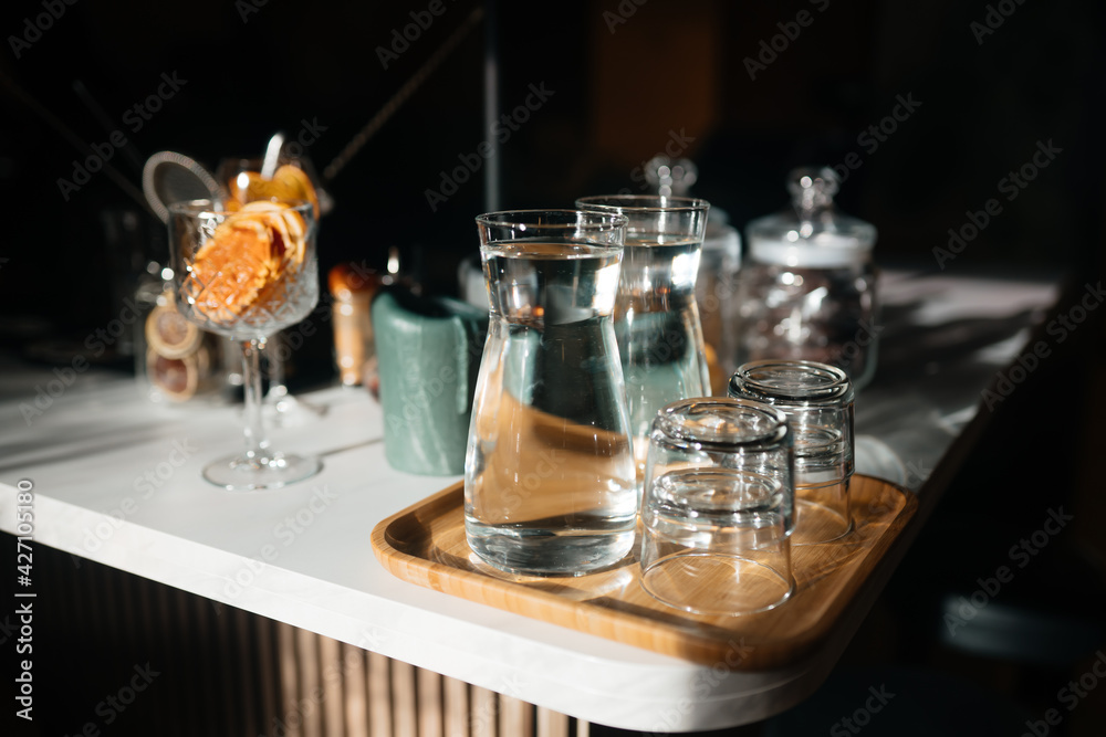 Four glass cups on the bar counter with serving accessories.