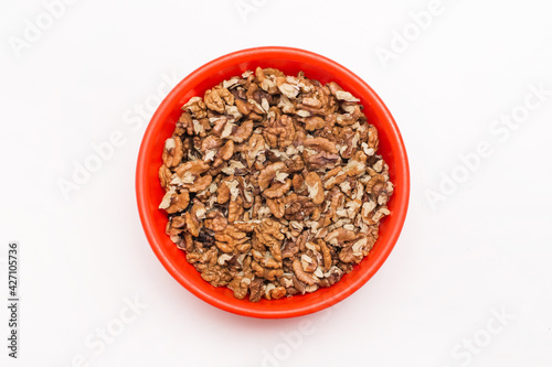 Peeled walnuts in red plastic plate on white background, isolated