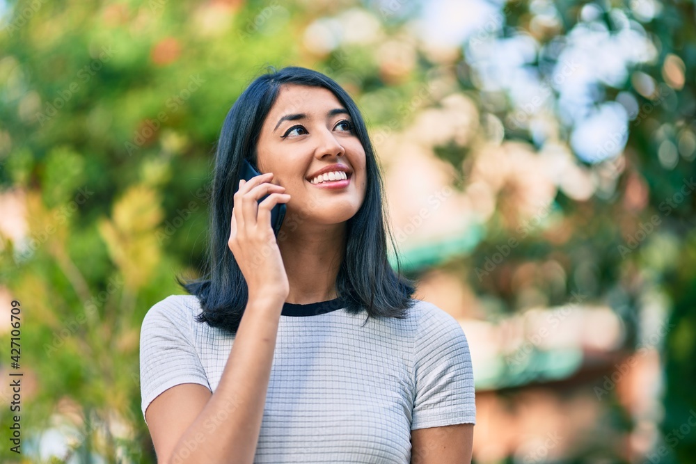 Young hispanic woman smiling happy talking on the smartphone at the city. Young hispanic woman smiling happy talking on the smartphone at the city.