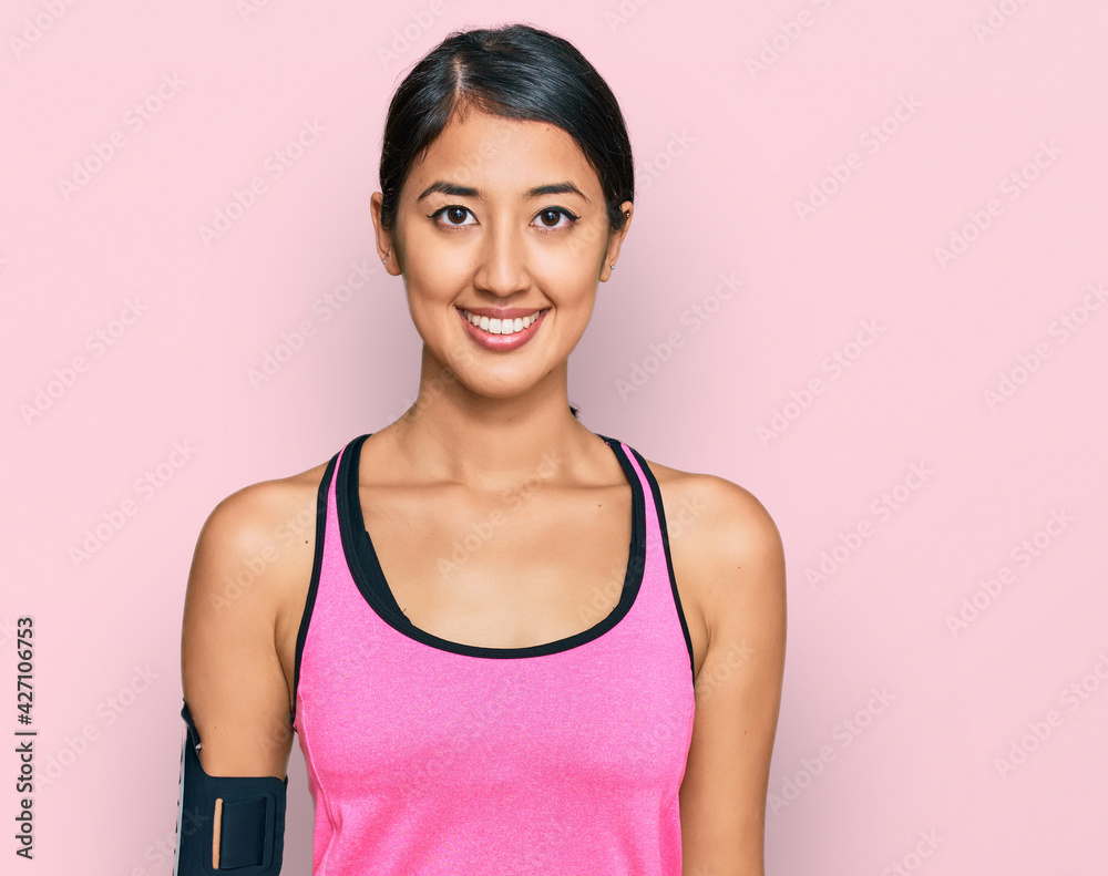 Beautiful asian young sport woman wearing sportswear and arm band with a happy and cool smile on face. lucky person. Beautiful asian young sport woman wearing sportswear and arm band with a happy and cool smile on face. lucky person.