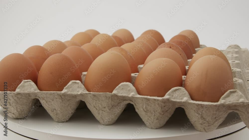 Eggs in a cardboard box, rotation shot, Chicken white fresh raw eggs in an egg container. Egg Box With Eggs On white Table Panning. Open egg box with ten brown eggs. Many fresh raw chicken eggs in car Eggs in a cardboard box, rotation shot, Chicken white fresh raw eggs in an egg container. Egg Box With Eggs On white Table Panning. Open egg box with ten brown eggs. Many fresh raw chicken eggs in car