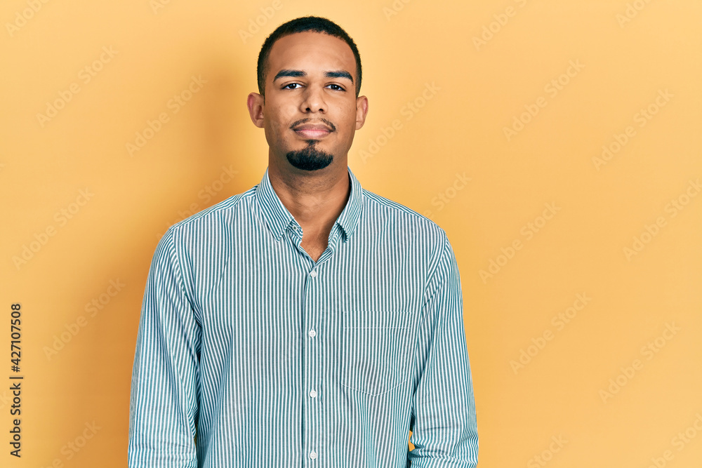 Young african american man wearing casual clothes with serious expression on face. simple and natural looking at the camera.