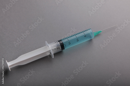 Syringe on a gray background. Cosmetology and medicine. Coronavirus vaccine concept. Flat lay.