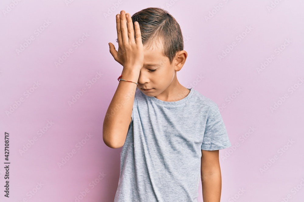 Adorable caucasian kid wearing casual clothes surprised with hand on head for mistake, remember error. forgot, bad memory concept. Adorable caucasian kid wearing casual clothes surprised with hand on head for mistake, remember error. forgot, bad memory concept.
