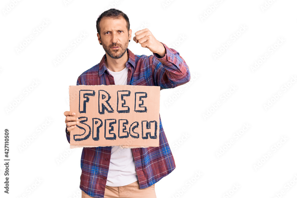 Young handsome man holding free speech banner annoyed and frustrated shouting with anger, yelling crazy with anger and hand raised Young handsome man holding free speech banner annoyed and frustrated shouting with anger, yelling crazy with anger and hand raised