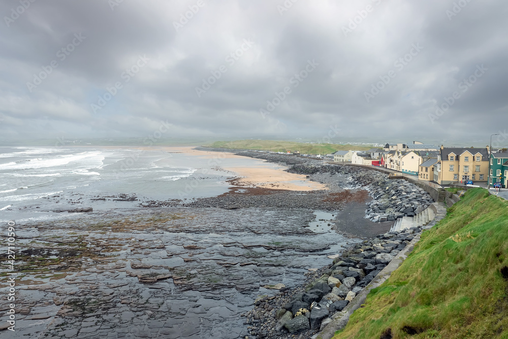 Water front of Lahinch town by Atlanic ocean, county Clare, Ireland, Low sky and tide. Powerful waves in the ocean