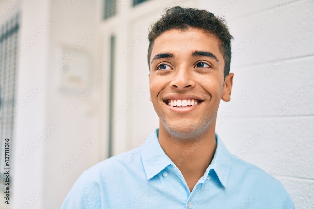 Obraz premium Young latin man smiling happy walking at the city.