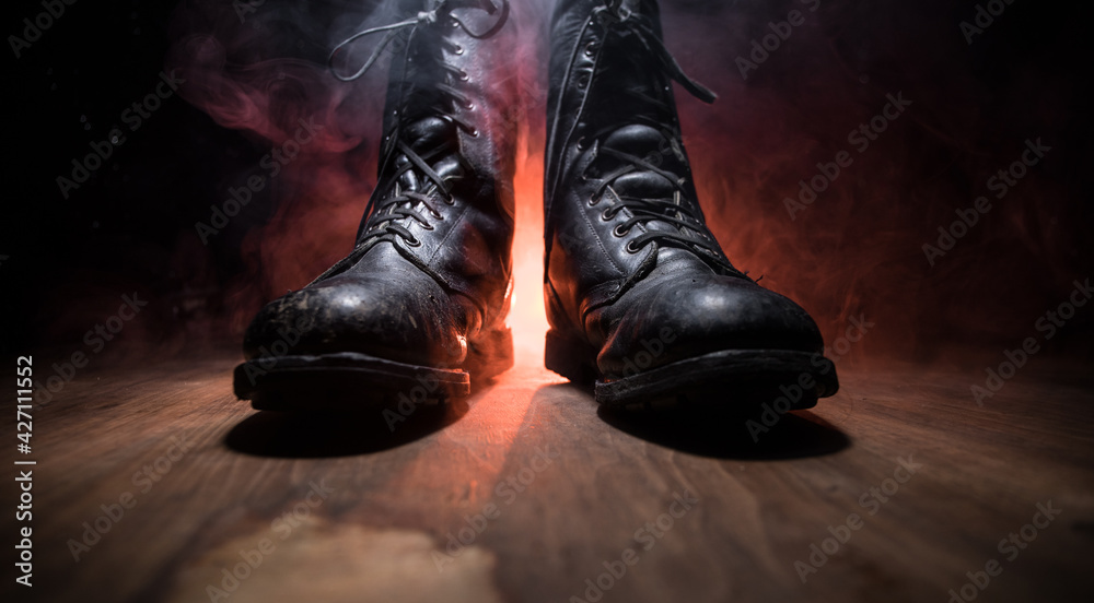 War concept. Old military shoe in a dark toned foggy background. Creative concept of conflict between countries, military aggression. War concept. Old military shoe in a dark toned foggy background. Creative concept of conflict between countries, military aggression.
