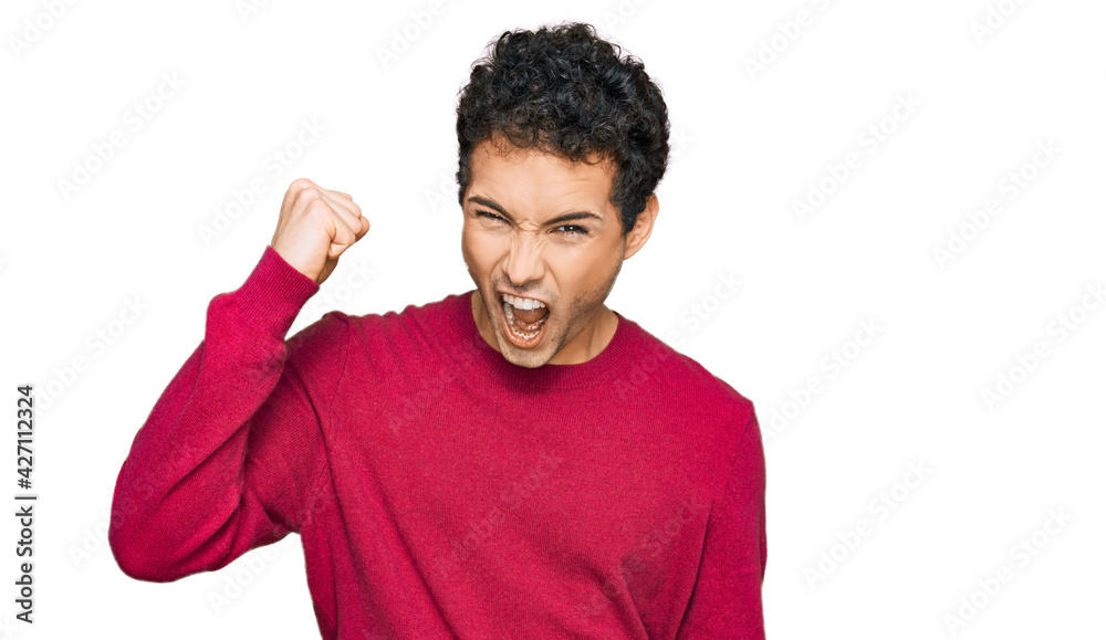 Young handsome man wearing casual clothes angry and mad raising fist frustrated and furious while shouting with anger. rage and aggressive concept. Young handsome man wearing casual clothes angry and mad raising fist frustrated and furious while shouting with anger. rage and aggressive concept.
