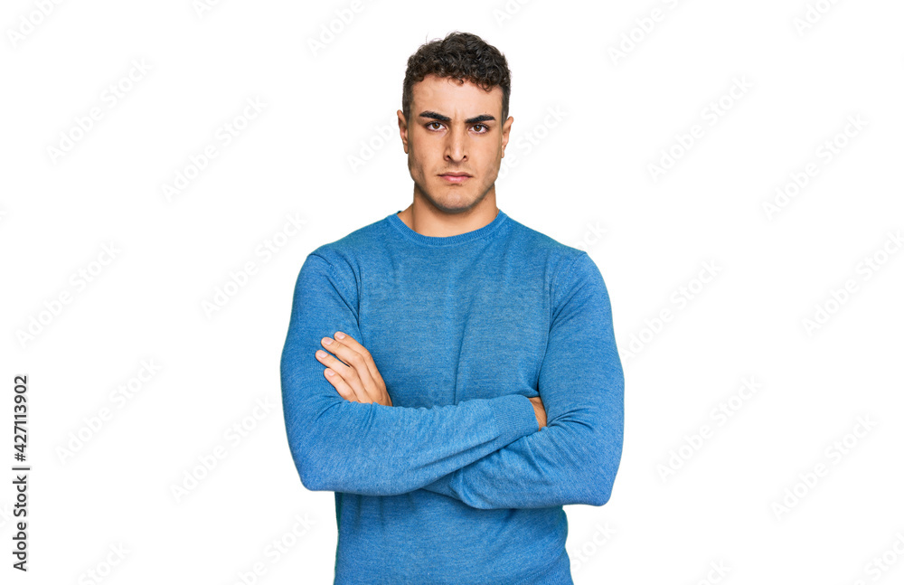 Hispanic young man wearing casual clothes skeptic and nervous, disapproving expression on face with crossed arms. negative person. Hispanic young man wearing casual clothes skeptic and nervous, disapproving expression on face with crossed arms. negative person.