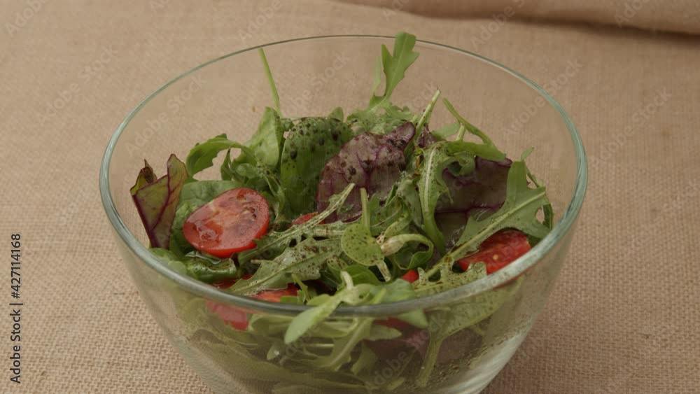 Female hands stir with wooden spoon green salad of tomatoes and fresh lettuce leaves. Concept of healthy eating and diet. Vegan vegetables food background. Preparation of fresh vegetable salad. Closeu Female hands stir with wooden spoon green salad of tomatoes and fresh lettuce leaves. Concept of healthy eating and diet. Vegan vegetables food background. Preparation of fresh vegetable salad. Closeu