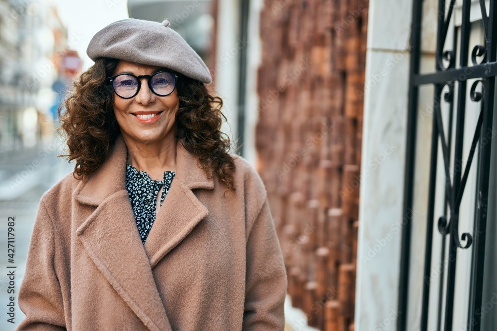 Obraz premium Middle age hispanic woman smiling happy standing at the city.