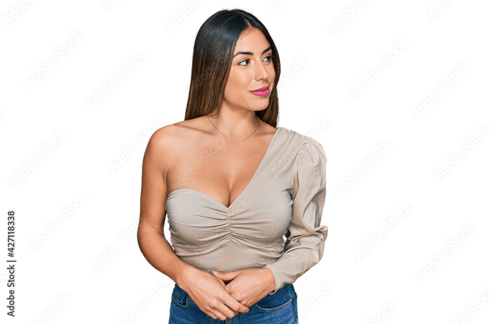 Young hispanic woman wearing casual clothes smiling looking to the side and staring away thinking. Young hispanic woman wearing casual clothes smiling looking to the side and staring away thinking.