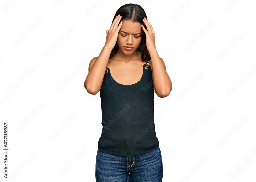 Beautiful hispanic woman wearing casual clothes suffering from headache desperate and stressed because pain and migraine. hands on head. Beautiful hispanic woman wearing casual clothes suffering from headache desperate and stressed because pain and migraine. hands on head.
