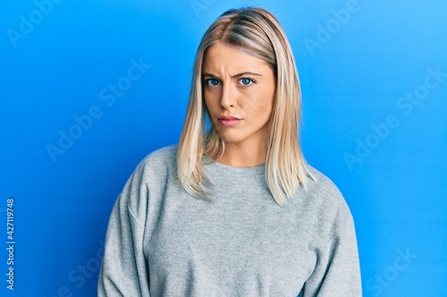 Beautiful blonde woman wearing casual clothes skeptic and nervous, frowning upset because of problem. negative person.