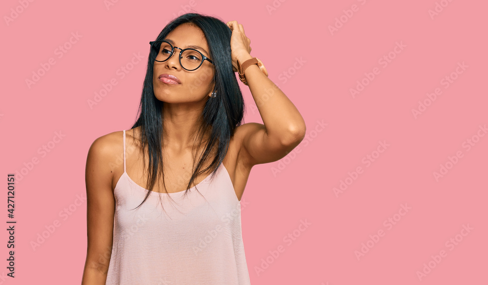 Young african american woman wearing casual clothes and glasses confuse and wondering about question. uncertain with doubt, thinking with hand on head. pensive concept.