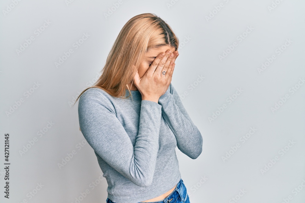 Young caucasian woman wearing casual clothes with sad expression covering face with hands while crying. depression concept. Young caucasian woman wearing casual clothes with sad expression covering face with hands while crying. depression concept.