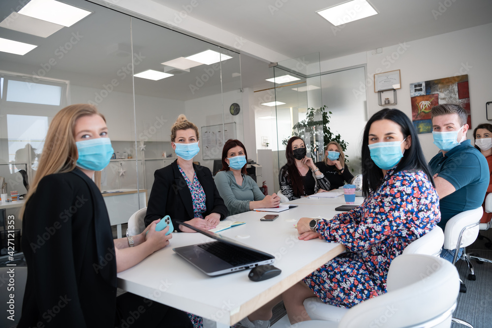 Naklejka premium real business people on meeting wearing protective mask