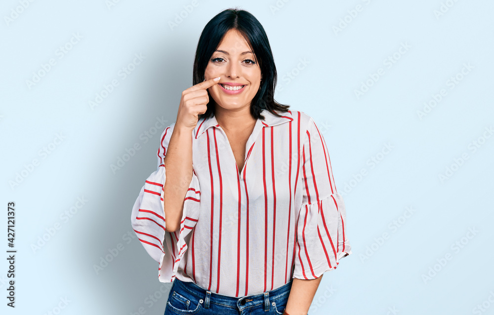 Young hispanic girl wearing casual clothes pointing with hand finger to face and nose, smiling cheerful. beauty concept Young hispanic girl wearing casual clothes pointing with hand finger to face and nose, smiling cheerful. beauty concept
