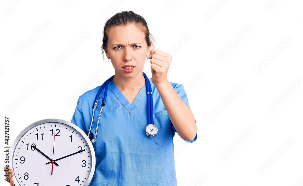 Young beautiful blonde woman wearing doctor uniform and stethoscope annoyed and frustrated shouting with anger, yelling crazy with anger and hand raised Young beautiful blonde woman wearing doctor uniform and stethoscope annoyed and frustrated shouting with anger, yelling crazy with anger and hand raised