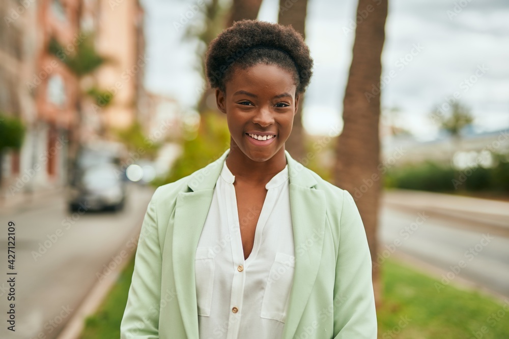 Obraz premium Young african american businesswoman smiling happy standing at the city